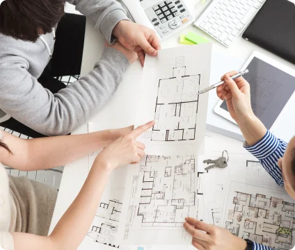 住宅の設計図を囲みながら打ち合わせをする手元
