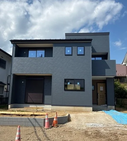 青空の下に建つ白い新築戸建住宅と玄関アプローチ